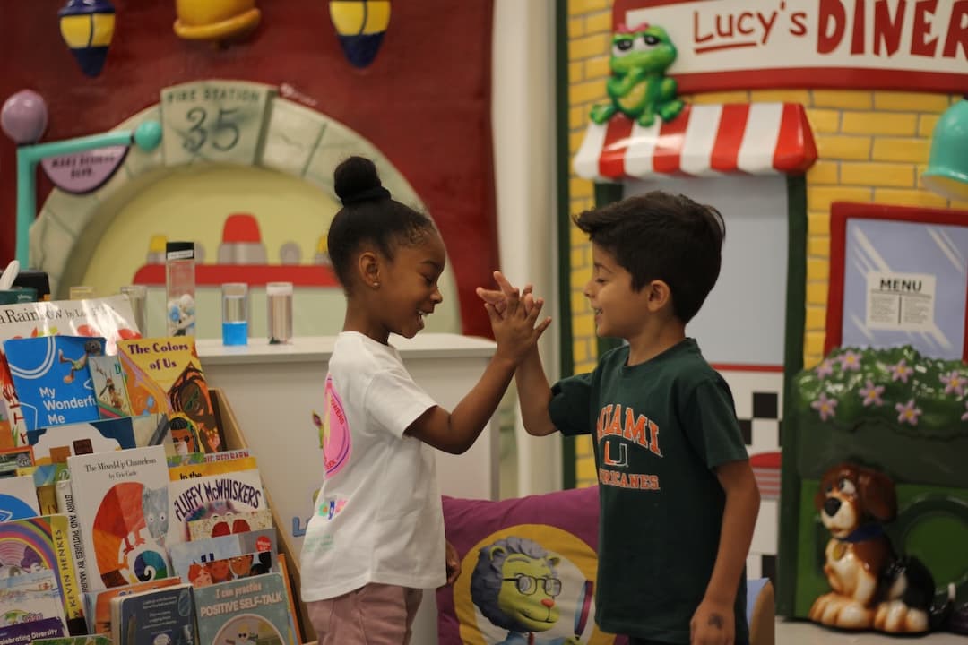A boy and girl give each other a high five.