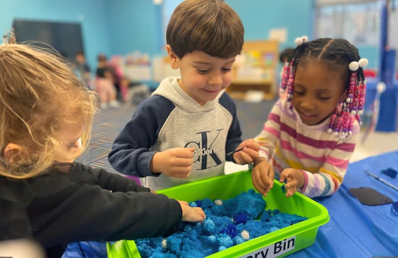 Kids play in a sensory bin.